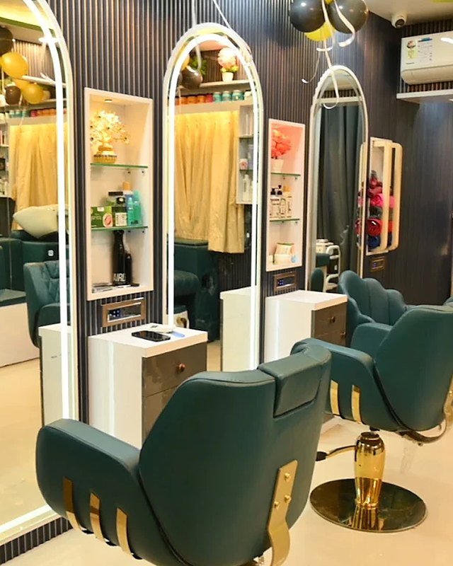 Inside the GlowKaya studio in Manjari Budruk, with teal styling chairs, arched lit mirrors and product shelves